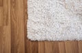 Close-up white carpet on laminate wood floor in living room, interior decoration