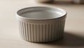 A close-up of a white ceramic ramekin with vertical fluting. The smooth, glossy surface reflects Royalty Free Stock Photo