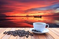 White coffee cup and coffee beans on wood table and view of suns Royalty Free Stock Photo