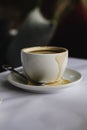 Close up of white coffee cup espresso spilt on saucer