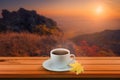 Close up white coffee cup on wood table and view of sunset or sunrise background Royalty Free Stock Photo