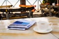 Close up white coffee cup on yellow table at sunrise sand beach with newspaper in the morning Royalty Free Stock Photo