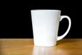 Close up of white coffee or tea cup on wooden table isolated on black background, copy space, clipping path Royalty Free Stock Photo