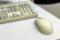 Close-up of white computer mouse on blurred PC keyboard background. Modern technology, information and communication concept Royalty Free Stock Photo