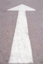 Close up white forward arrow on running track. Asphalt walk way in park. Stock photography.