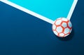 Close-up of a futsal soccer ball laying on the line in the corner of a blue indoor soccer field