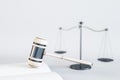 Close up of white gavel, scales and book/journal on light backdrop. Lawyer, justice and punishment concept. Royalty Free Stock Photo