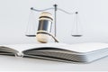 Close up of white gavel, scales and book/journal on light background. Lawyer, justice and punishment concept.