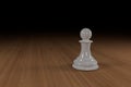 Close up of a white, glass, chess pawn on a wooden surface Royalty Free Stock Photo