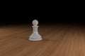 Close up of a white, glass, chess pawn on a wooden surface Royalty Free Stock Photo