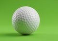 Close up of a white golf ball with dimples on a green surface in a studio setting with soft lighting Royalty Free Stock Photo