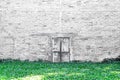 White gray brick wall texture in seamless patterns with old door and green grass for space background Royalty Free Stock Photo