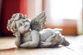 Sculpture of a white guardian angel lying on the wooden floor