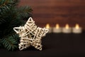 White rotang star next to a Christmas tree with candles at the background Royalty Free Stock Photo