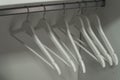 Close up of white hangers. Clothes on a rail in a wardrobe.