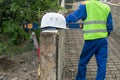 Close-up of a white helmet against the background of a worker in a yellow vest at a construction site Royalty Free Stock Photo