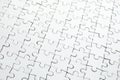 Close up of a white jigsaw puzzle in assembled state in perspective. Many components of a large whole mosaic are united