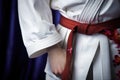 close-up of a white karate belt tied around a gi