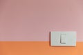 Close up of white Light Switch with copy space on pink and orange wall. Royalty Free Stock Photo