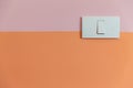 Close up of white Light Switch with copy space on pink and orange wall. Royalty Free Stock Photo