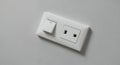 Close Up of White Light Switch and Electrical Socket on Textured Wall for Home Renovation Electrical Work and Interior Royalty Free Stock Photo