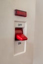 A close-up of a white light switch on a plain wall. Royalty Free Stock Photo