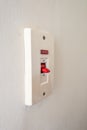 A close-up of a white light switch on a plain wall. Royalty Free Stock Photo