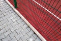 Close-up of white marking lines of outdoor basketball court fenced with protective metal fence Royalty Free Stock Photo