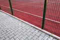 Close-up of white marking lines of outdoor basketball court fenced with protective metal fence Royalty Free Stock Photo