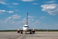 close-up of a white modern airplane at an airport in an empty parking lot against a cloudy sky Royalty Free Stock Photo