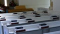 close up of white painted pews in a small English church with hymn books neatly stacked