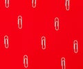 Close-up of white paper clips on a red background. School stationery pattern Royalty Free Stock Photo