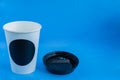 Close up of white paper kraft disposable cup for coffee with black plastic lid on blue background with copy space Royalty Free Stock Photo