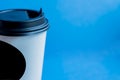 Close up of white paper kraft disposable cup for coffee with black plastic lid on blue background with copy space Royalty Free Stock Photo