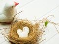 close up of white pigeon statue bird and bird nest with three white stone on white background and copy space