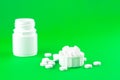 Close up white pill bottle with spilled out pills and capsules in cap on lime green background with copy space. Focus on foregroun Royalty Free Stock Photo