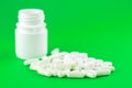 Close up white pill bottle with spilled out pills and capsules on lime green background with copy space. Focus on foreground, soft Royalty Free Stock Photo