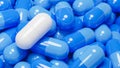 Close up of white pill capsule in many blue pills capsules. Medicine and Specialty Pharmaceuticals concept.,3d model and Royalty Free Stock Photo