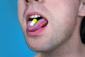 Close-up of a white pill in the male`s mouth. Royalty Free Stock Photo