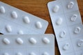 Close-up of White pills in blister packets on a wooden surface Royalty Free Stock Photo