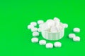 Close up white pills and capsules in cap on lime green background with copy space. Focus on foreground, soft bokeh. Pharmacy drugs Royalty Free Stock Photo