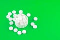 Close up white pills and capsules in cap on lime green background with copy space. Focus on foreground, soft bokeh. Pharmacy drugs Royalty Free Stock Photo