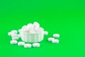 Close up white pills and capsules in cap on lime green background with copy space. Focus on foreground, soft bokeh. Pharmacy drugs Royalty Free Stock Photo