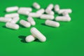 close up of white pills capsules on green background Royalty Free Stock Photo