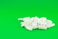 Close up white pills and capsules on lime green background with copy space. Focus on foreground, soft bokeh. Pharmacy drugstore co Royalty Free Stock Photo