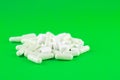 Close up white pills and capsules on lime green background with copy space. Focus on foreground, soft bokeh. Pharmacy drugstore co Royalty Free Stock Photo