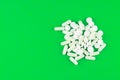 Close up white pills and capsules on lime green background with copy space. Focus on foreground, soft bokeh. Pharmacy drugstore co Royalty Free Stock Photo