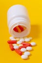 Close-up white pills falling from plastic jar Royalty Free Stock Photo