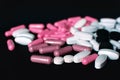 Close up of white and pink pills on dark background