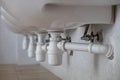 Close up of white plastic pipe drain under washing sink in bathroom